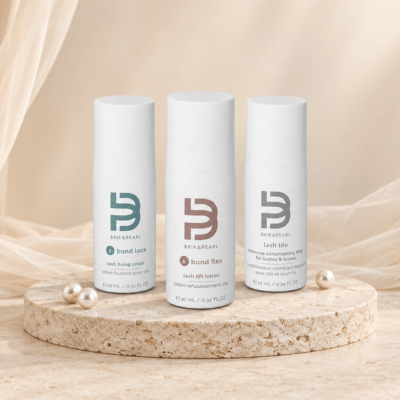 3 white product bottles on stone with pearls